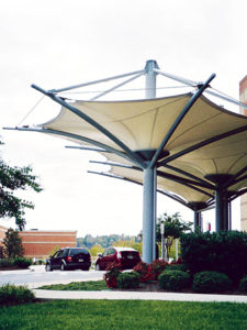 As a cost-saving alternative to a glass-and-steel entry canopy, this tensioned fabric canopy provides shade and internal rainwater drainage through inverted fabric cones. Photo: Huntington Design Associates Inc.