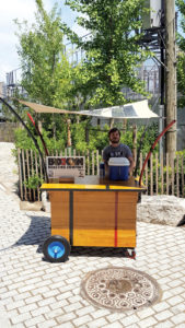 Flexible composite PV makes a logical high-tech choice for portables. New York-based Pvilion designed the mobile Coffee Court for the Brooklyn (N.Y.) Roasting Company. Constructed of vintage reclaimed wood from basketball courts, the relocatable business is powered by a laminated shade canopy that incorporates a Pvilion photovoltaic unit, which provides up to 200 watts to power the cash register and refrigeration for iced coffee drinks. Photo: Pvilion.