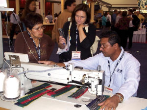 A Kaplan technician demonstrates the company's fully automated sewing machine at IFAI Expo 2007. President Steven Kaplan cites the higher efficiency and lower cost of modern automated sewing machines; he likens yesterday's machines to outdated computers. Photo: Kaplan Sewing Machine Co. Inc.
