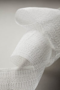 For casts that protect broken bones while they heal, AEC adds a resin to polyester fabric that softens with water and then dries to a hard finish. Photo: AEC Narrow Fabrics