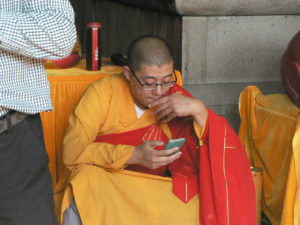 A Chinese monk checks his smartphone between Buddhist services at the Yuanjin Buddhist Temple, Zhujiajiao, Shanghai. Photo: Dr. James Chan