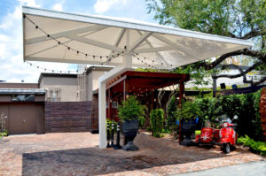 An entrance cover and umbrella for the valet area in front of Louie Bossi’s Ristorante in Fort Lauderdale, Fla. The umbrella frame is electrostatically painted steel. The walkway frame is aluminum with a specialty powder-coat application to give it a wood-grain appearance. Photo: Awnings of Hollywood