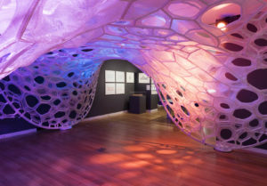 Installation view of the PolyThread knitted textile pavilion, designed by Jenny E. Sabin, commissioned for Beauty—Cooper Hewitt Design Triennial. Photo by Matt Flynn © 2016 Cooper Hewitt, Smithsonian Design Museum. PolyThread knitted textile pavilion, 2015–16 Designed by Jenny E. Sabin, Jenny Sabin Studio Design Team: Martin Miller, Charles Cupples Fabricated by Shima Seiki, WHOLEGARMENT Engineering Design by Arup Fabric finishing by Andrew Dahlgren Final finishing, sewing, and assembly by All Sewn Together 3D seamless Whole Garment digitally knit cone elements, photoluminescent, solar active and drake yarns; twill tape; aluminum armature Commissioned by Cooper Hewitt, Smithsonian Design Museum