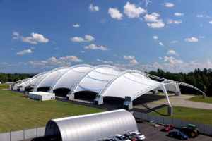  Reaching a maximum height of 115 feet, this 700-foot-long by 300-foot-wide dome engineered and fabricated by Dünn Lightweight Architecture is one of the largest fabric-covered structures in the U.S. Photo: IIHS. Six fabric panels are supported by seven steel trusses, which are supported by 18 concrete piers—each of which is 30 percent underground—weighing a total of 7,000 tons and containing more than 39 miles of steel reinforcement bars. Photo: IIHS.