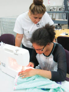 Sewing instructor Angela Herrera teaches upholstery skills in Tarrant County College NW’s summer course, Career Exploration Camp. The course provides students entering 7th and 8th grades the opportunity to explore careers and to learn about work readiness and entrepreneurship. Photo: Robin Valetutto, TCC NW CIE. 