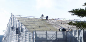 Workers are installing protective fabrics on the roof of the Ebino Eco Museum Center in Krishima-Kinkowan National Park in southern Japan, as insurance against any future airborne volcanic fragments from nearby volcanoes. Fabric woven from highly durable and heat-resistant para-aramid fibers of Twaron™ and Technora™ from Teijin Ltd. offer protection mandated by new government regulations. Photo: Teijin Ltd.