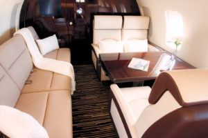JetSet Interiors fully refurbished the interior of a Bombardier Challenger 605 business aircraft. The seats are cowhide leather. The divan is covered in a woven fabric with bouclé yarn called Ramor from Osborne & Little. The sidewalls and headliner are Ultraleather®. The cabinetry is wood veneer with a gloss finish. Photo: JetSet Interiors.