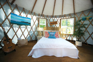 The interior of a 16-foot yurt built for a client in July 2016 showcases the wood lattice walls  and roof rafters that are built around a central compression ring, which keeps the yurt stable.