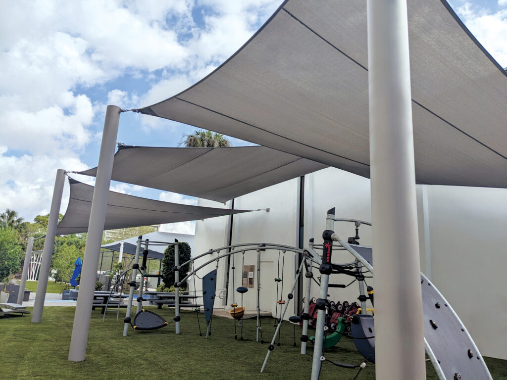 After: Three overlapping shade sails now shade the playground and seating area.