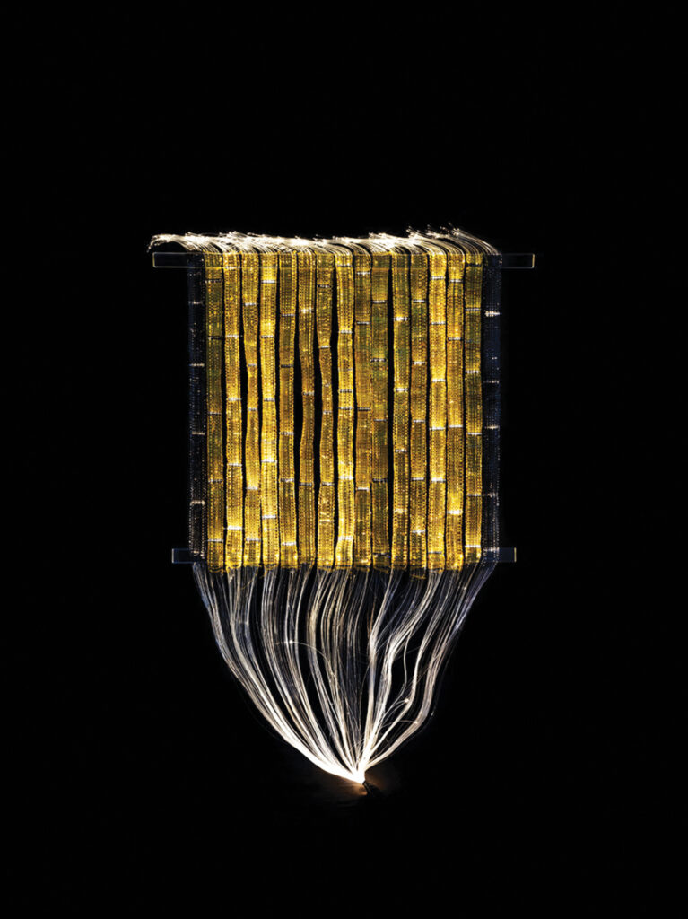 Corridor of Light, a 2008 artwork by Maija Lavonen. It features linen yarn and acrylic rods woven on a fiber-optic loom with light projected on it to create different shapes.