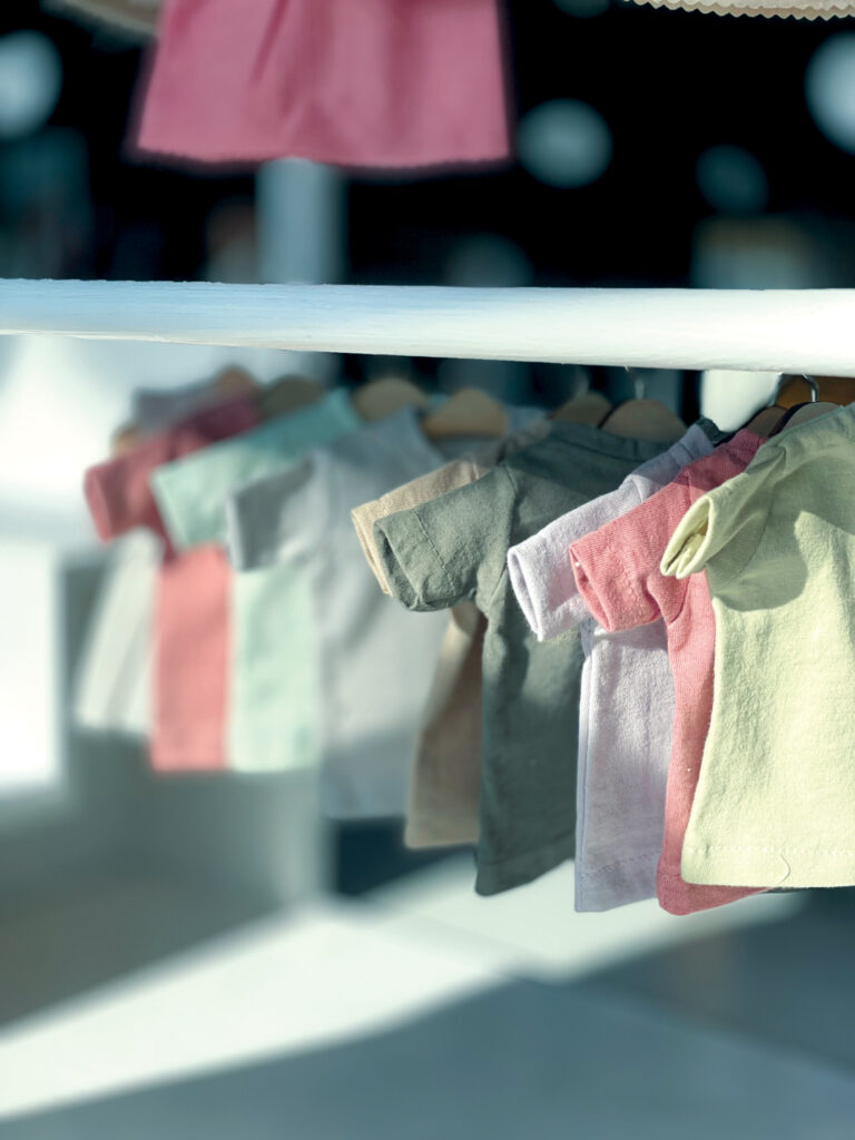 Several infant tops using a spring/summer palette of dyes from Post Carbon Lab.