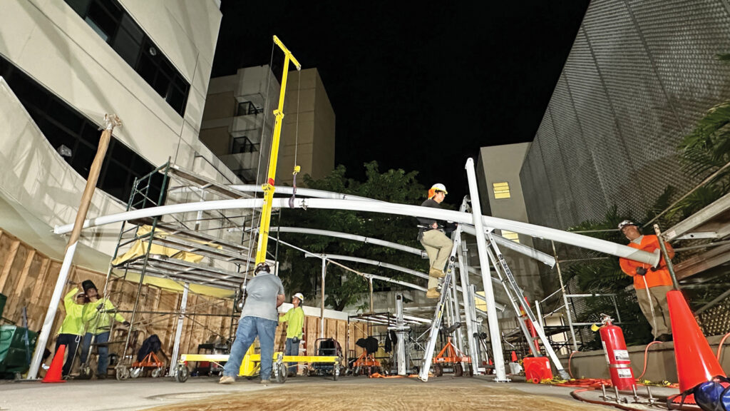 Tropical J’s Installers use a roustabout to hoist a 1,700-pound rafter at Straub Medical Center in Honolulu, Hawaii