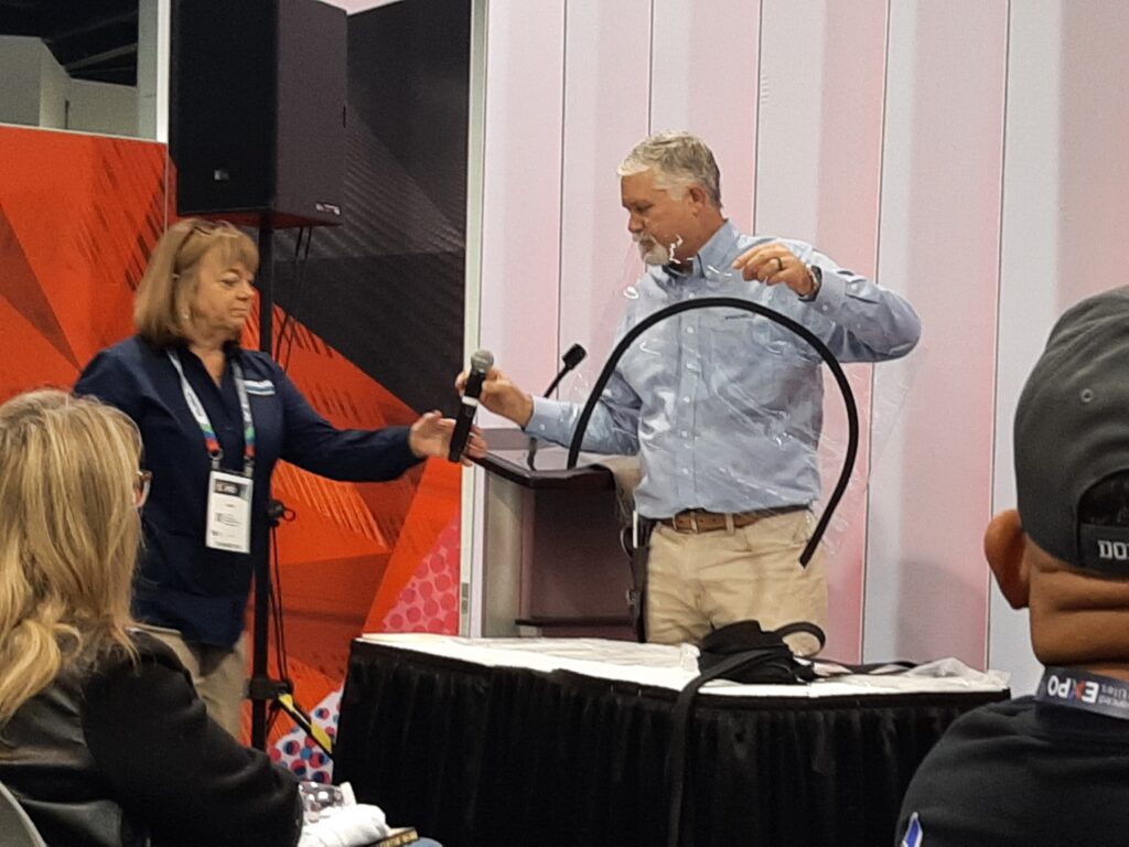 A man demonstrates Installing a curved zipper on window fabric at Marine Fabricators Association Road Show in 2024