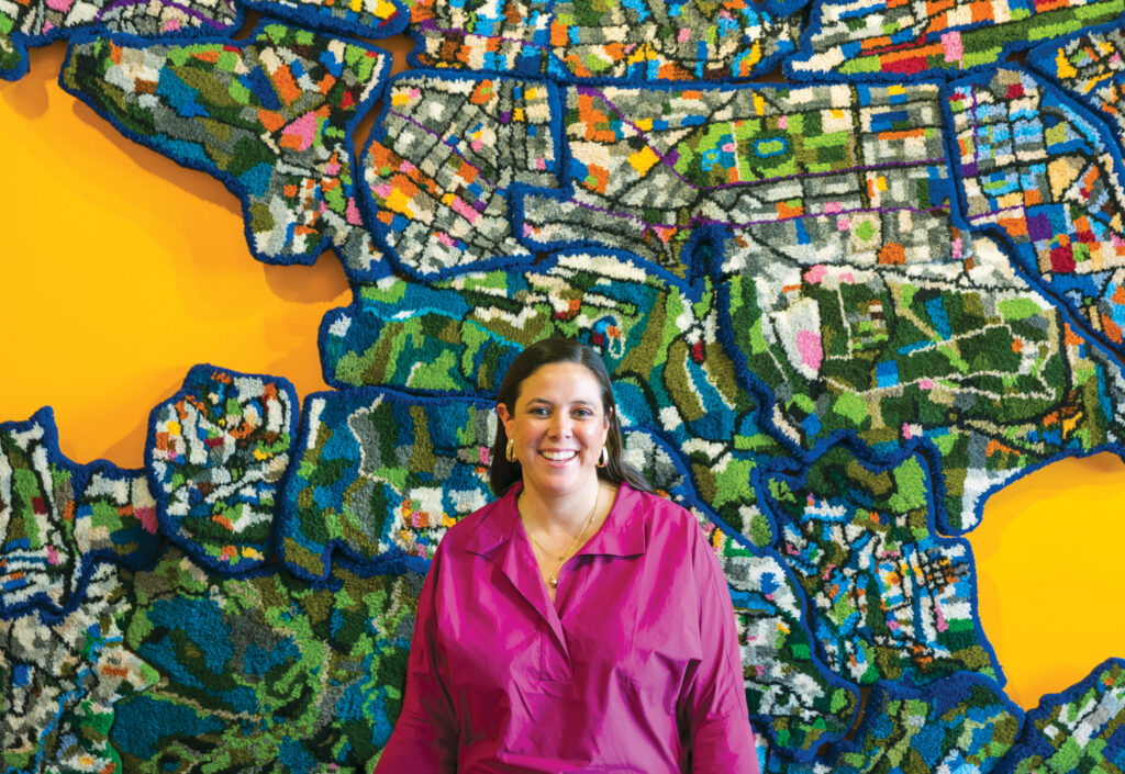 María Isabel Paz in front of her rug artwork Quito Fragmented, which is an abstract inspired by a map of the city