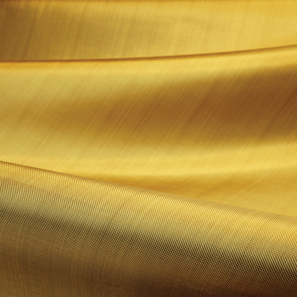 A close-up of Kevlar EXO fabric, which is golden in color