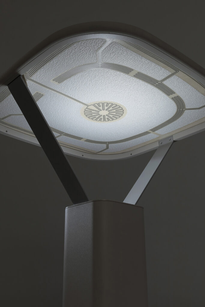 A close-up of the underside of the tensioned textile lamp showing what the conductive paths look like. They are dark gray on a buff background. The textile of the lamp is white.