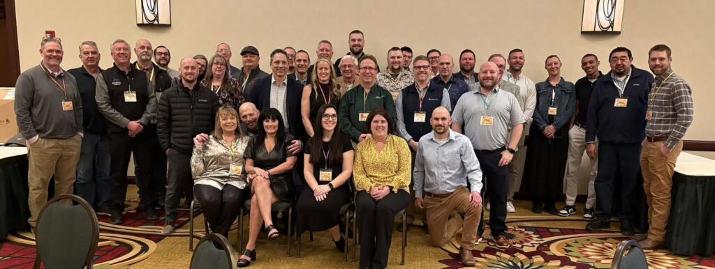 Group photo of an assembly of professionals in a conference setting.