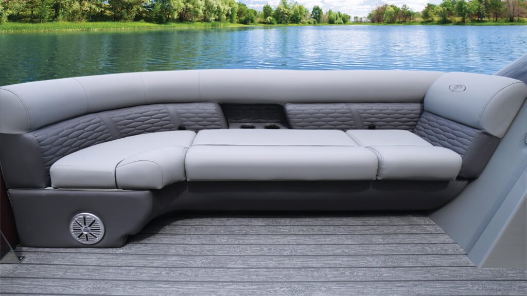 L-shaped grey and light grey upholstered seating with quilted detailing, beside a lake.