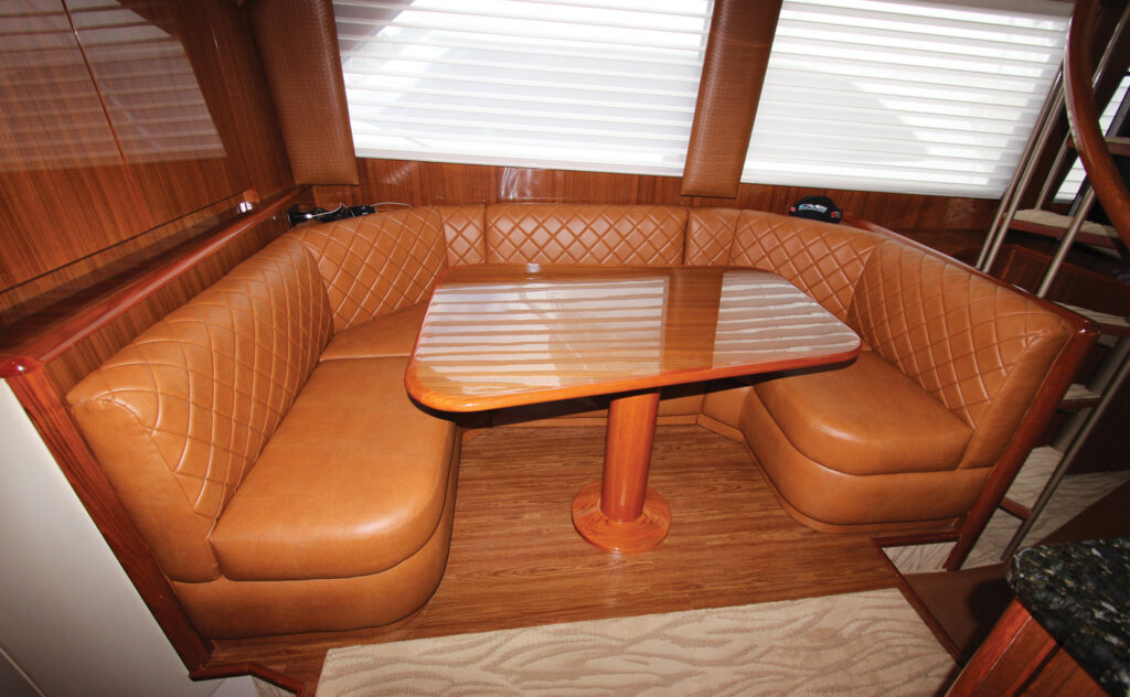 Leather-upholstered seating in a corner with a wooden table, complemented by wood paneling.