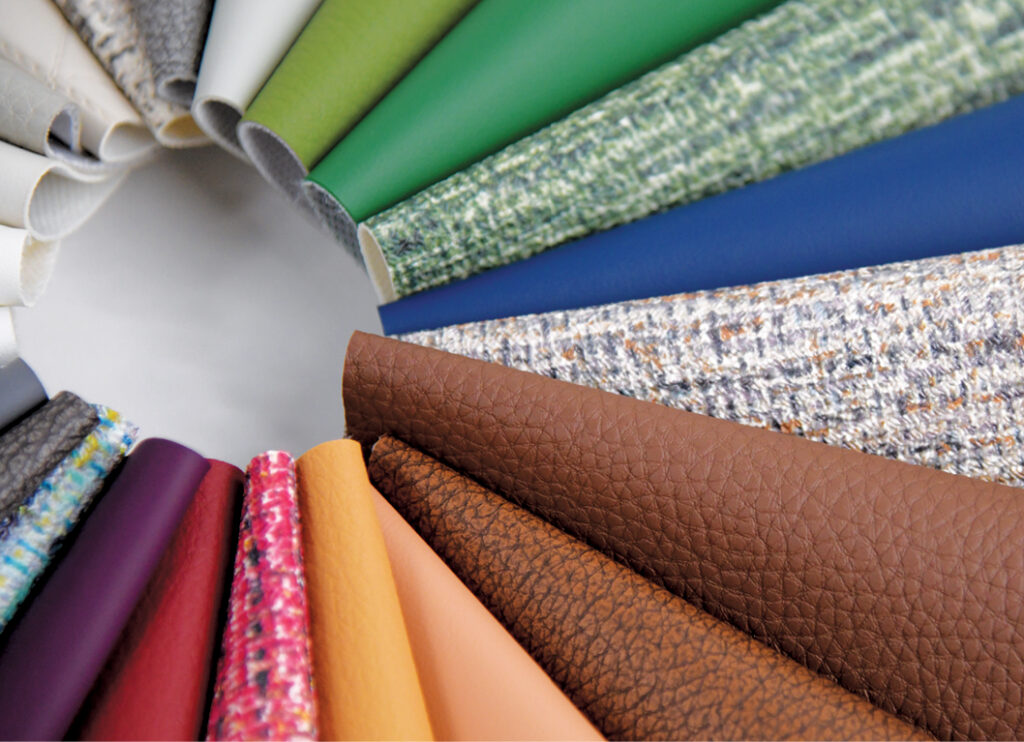 A circular array of fabric samples in various colors and textures, including leather, woven, and solid materials, displaying diversity in design.