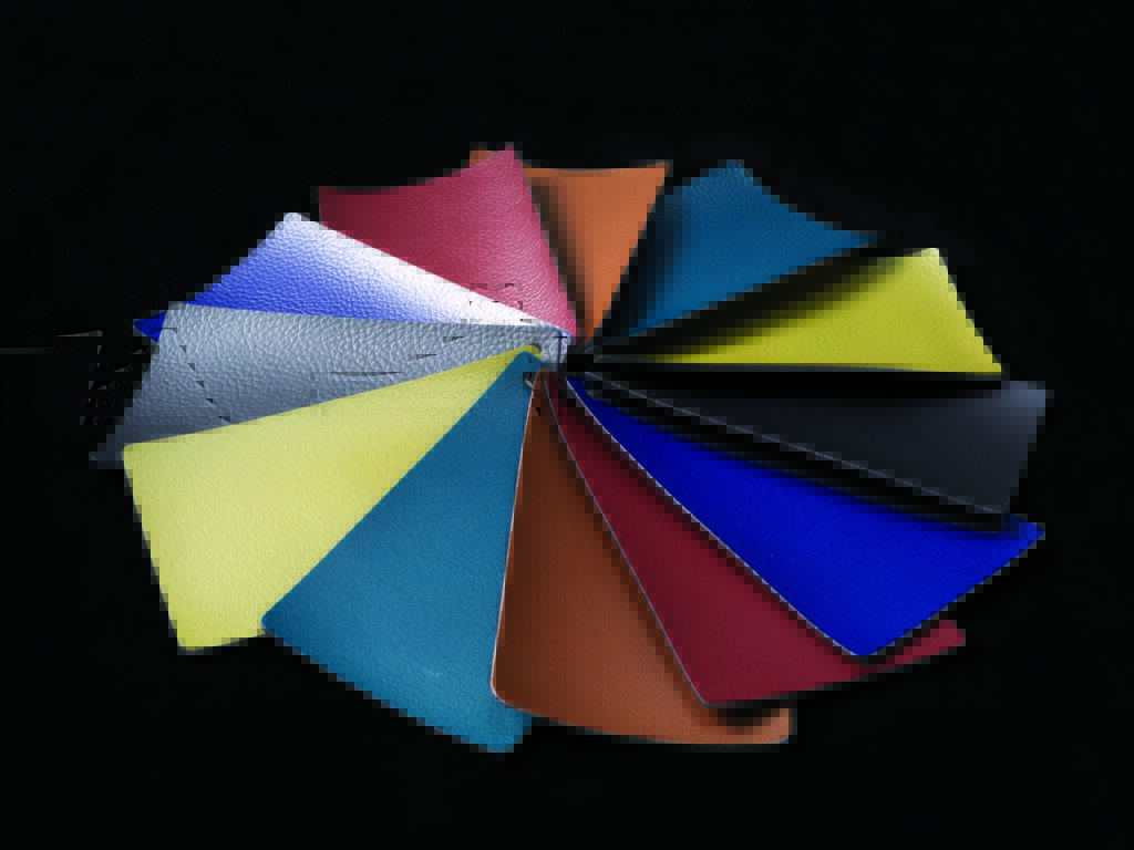 Twelve swatches of textured fabric arranged in a circular pattern, featuring various vibrant colors on a black background.