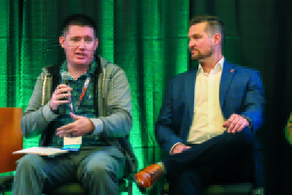 Joseph Lorelli (left) and Kurt Schimmel participated in a workforce panel discussion at Advanced Textiles Association’s Outlook® Leadership Conference in Green Bay, Wis., in 2025. Here they sit on a stage against a green backdrop.