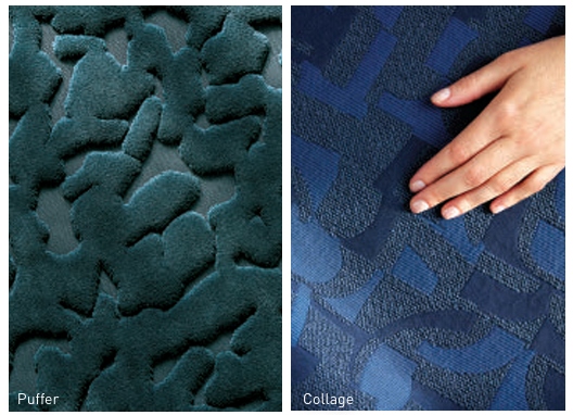 Designtex NP Textured fabric samples in deep teal and navy shades, featuring abstract designs; one sample is shown with a hand touching it.