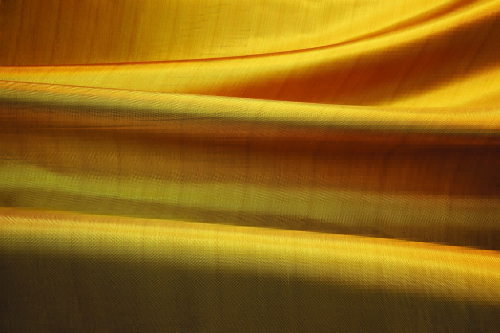 A picture of cascading golden Kevlar EXO fabric, showcasing its rich tones.