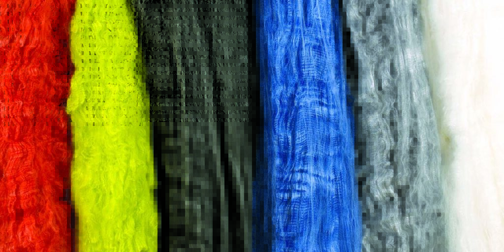Colorful puffs of Nomex aramid fibers displayed in rows, featuring vibrant hues of red, yellow, black, blue, gray, and white.