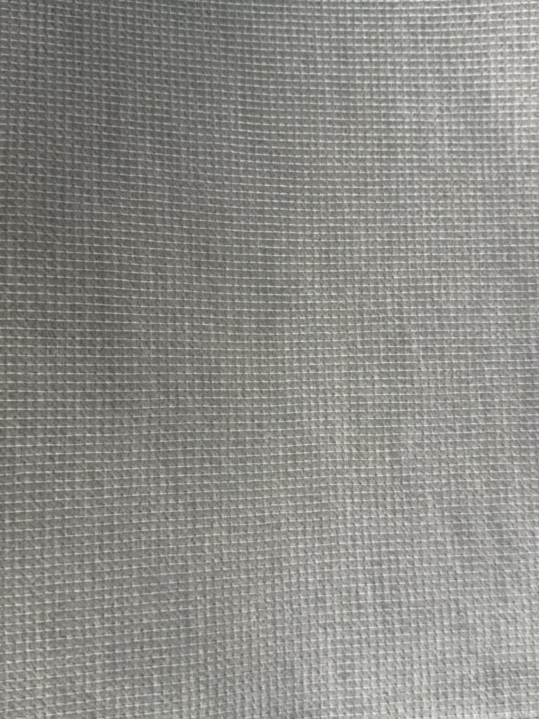 endure Textured grey fabric with a grid pattern, showcasing a fine weave and a smooth surface, suitable for fire-resistant applications.
